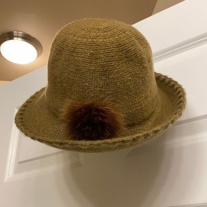 Olive green bucket hat with brown fuzzy pouf